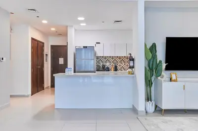 a kitchen with a large white island in a room at Bright 2 BHK in Prime Location in Dubai