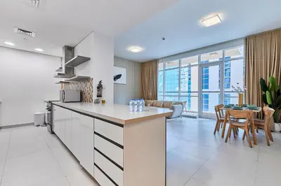 a kitchen and living room with a table and chairs at Bright 2 BHK in Prime Location in Dubai