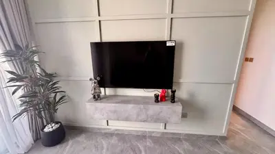 a flat screen tv sitting on a white wall at Elegant 1BHK Sea View Apartment City View in Dubai