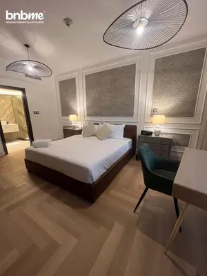 a bedroom with a bed and a table and a chair at bnbmehomes - Burj Views East Tower in Dubai