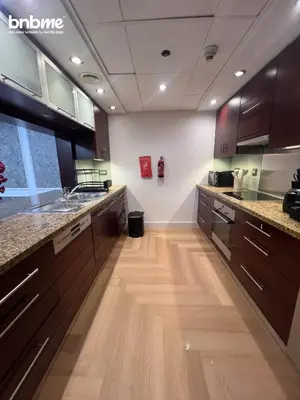 a large kitchen with wooden floors and cabinets at bnbmehomes - Burj Views East Tower in Dubai