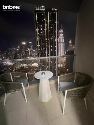 a table and chairs on a balcony with a view of a city at bnbmehomes - Burj Views East Tower in Dubai