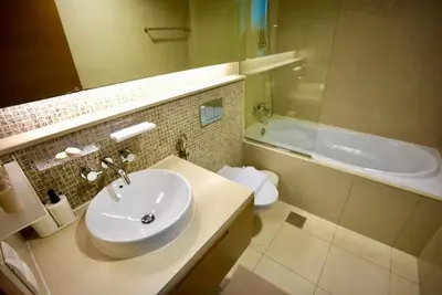 a bathroom with a sink and a tub and a toilet at Elite Downtown 1BR Stylish 1BR in Dubai