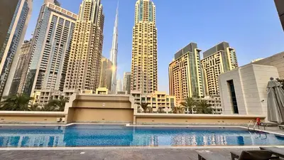 a large swimming pool in a city with tall buildings at Elite Downtown 1BR Stylish 1BR in Dubai