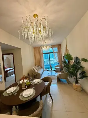 a living room with a dining table and a chandelier at Elite Downtown 1BR Stylish 1BR in Dubai