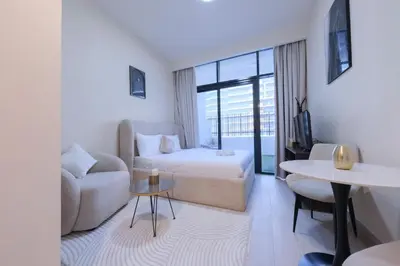 a living room with a bed and a couch and a table at Premium Studio near Meydan Azizi Riviera 46 in Dubai