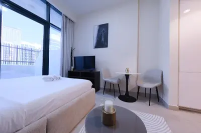 a hotel room with a bed and a table and chairs at Premium Studio near Meydan Azizi Riviera 46 in Dubai