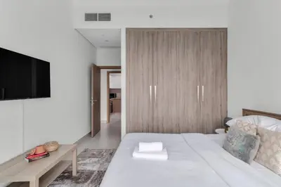 a bedroom with a large white bed and a tv at GuestReady – Business Bay Bliss | Near Dubai Mall in Dubai