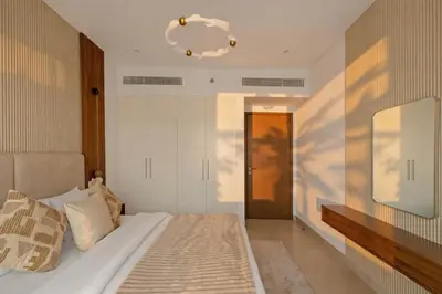 a bedroom with a bed with a mirror and a door at 1 Bedroom Apartment in Central Park, City Walk in Dubai