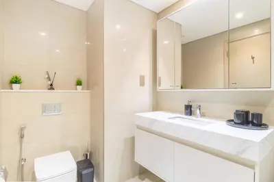 a bathroom with a white sink and a toilet at Elite Burj Khalifa Fountain 4 BR Flat in Dubai