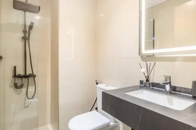 a bathroom with a toilet and a sink and a mirror at Elite Burj Khalifa Fountain 4 BR Flat in Dubai