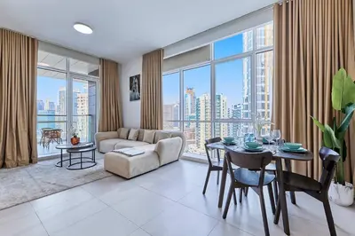 a living room with a table and a couch at Bright 1 BHK in Prime Location in Dubai