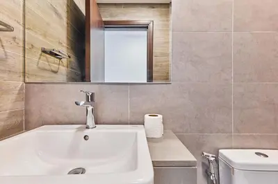 a bathroom with a sink and a toilet and a mirror at Bright 1 BHK in Prime Location in Dubai