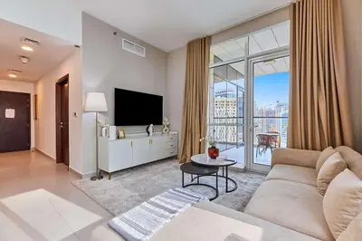 a living room with a couch and a tv at Bright 1 BHK in Prime Location in Dubai