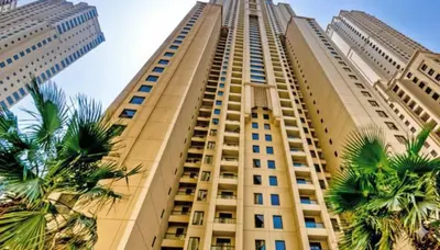 a tall building with palm trees in front of it at Dubai Short Stay Vacation Homes Rental Room in Dubai