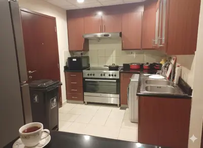 a kitchen with a sink and a stove top oven at Dubai Short Stay Vacation Homes Rental Room in Dubai