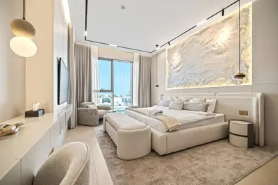 a white bedroom with a large bed and a desk at Serene Waterfront Gem UPSCALE in Dubai