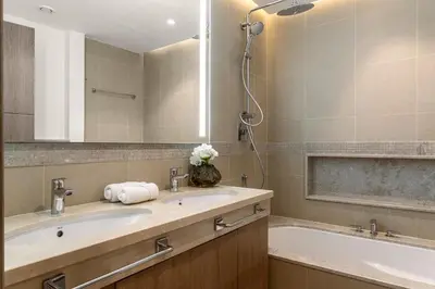 a bathroom with two sinks and a tub and a mirror at Paradise Retreats 3BR Burj Khalifa & Fountain view in Dubai