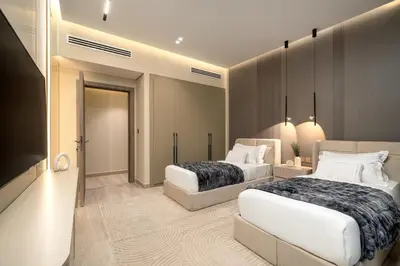 a bedroom with two beds and a flat screen tv at Paradise Retreats 3BR Burj Khalifa & Fountain view in Dubai