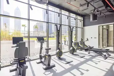 a gym with cardio equipment and a large window at Stunning Studio With Burj Khalifa & Canal Views in Dubai
