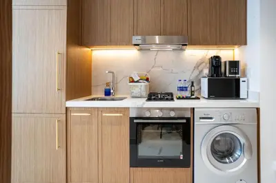 a kitchen with a sink and a washing machine at Airstay - Chic Studio in Meydan Azizi 65 - Monthly Offer Available in Dubai