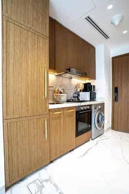 a kitchen with wooden cabinets and a dishwasher at Airstay - Chic Studio in Meydan Azizi 65 - Monthly Offer Available in Dubai
