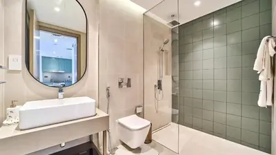 a bathroom with a sink toilet and a mirror at Stylish 1 Bedroom in Viridian City Walk in Dubai