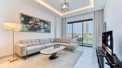 a living room with a couch and a tv at Stylish 1 Bedroom in Viridian City Walk in Dubai