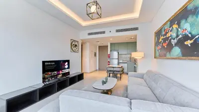 a living room with a couch and a flat screen tv at Stylish 1 Bedroom in Viridian City Walk in Dubai