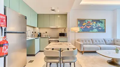 a kitchen and living room with a table and a couch at Stylish 1 Bedroom in Viridian City Walk in Dubai