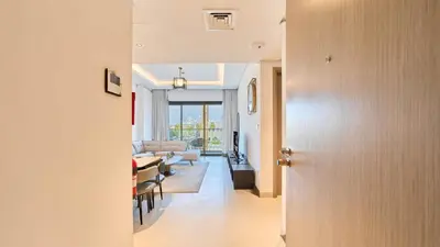 a hallway leading to a living room with a couch at Stylish 1 Bedroom in Viridian City Walk in Dubai