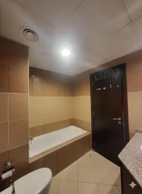 a bathroom with a tub and a toilet and a sink at Luxury 2BR with Maid Burj Khalifa and Canal View in Dubai