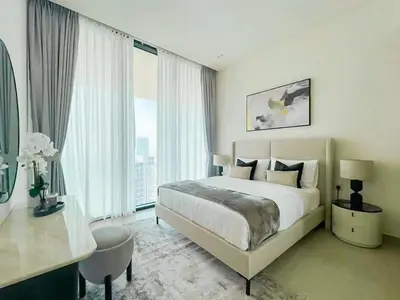 a bedroom with a large bed and a desk and window at Binghatti Royale Luxe 1BR Serenity with Private Pool! in Dubai