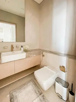 a bathroom with a toilet and a sink and a mirror at Binghatti Royale Luxe 1BR Serenity with Private Pool! in Dubai
