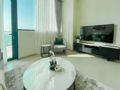 a living room with a glass table and a tv at Binghatti Royale Luxe 1BR Serenity with Private Pool! in Dubai