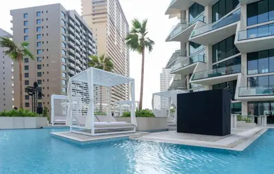 a swimming pool with two chairs and a building at Binghatti Royale Luxe 1BR Serenity with Private Pool! in Dubai