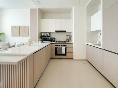 a large kitchen with white cabinets and appliances at Calm Luxe 1BR Suite in Binghatti Royale with Parking! in Dubai