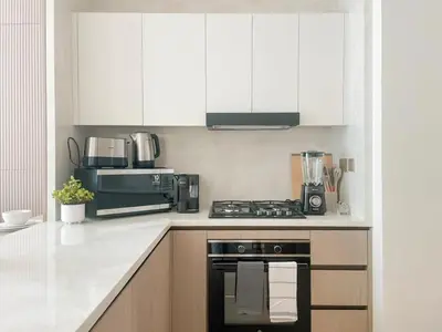a kitchen with white cabinets and a stove top oven at Calm Luxe 1BR Suite in Binghatti Royale with Parking! in Dubai
