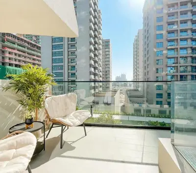 a balcony with chairs and a view of buildings at Calm Luxe 1BR Suite in Binghatti Royale with Parking! in Dubai
