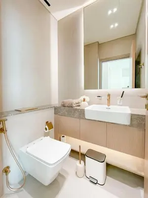 a bathroom with a sink and a toilet and a mirror at Calm Luxe 1BR Suite in Binghatti Royale with Parking! in Dubai