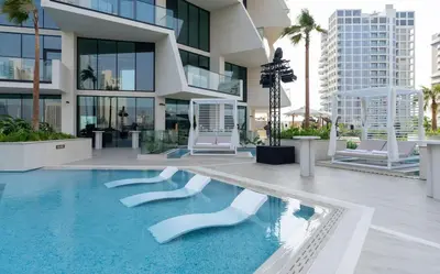 a large building with a swimming pool in front of it at Calm Luxe 1BR Suite in Binghatti Royale with Parking! in Dubai