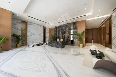 a lobby with a large white marble floor and a couch at Warm-Toned Studio with City Views in Binghatti Azure in Dubai