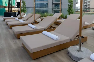 a row of chaise lounges in a building at Calm 1BR Haven with Private Pool in Binghatti Royale in Dubai