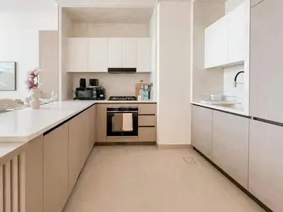 a white kitchen with white cabinets and appliances at Calm 1BR Haven with Private Pool in Binghatti Royale in Dubai