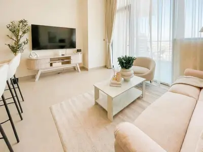 a living room with a couch and a tv at Calm 1BR Haven with Private Pool in Binghatti Royale in Dubai