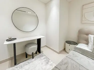 a white room with a mirror and a desk and a bed at Family-Friendly 1BR Apt with Study Room and Pool Views! in Dubai