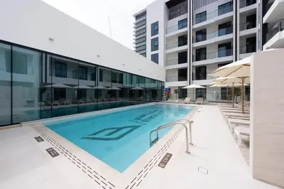 a large swimming pool next to a building at Family-Friendly 1BR Apt with Study Room and Pool Views! in Dubai