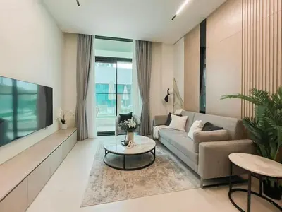 a living room with a couch and a table at Family-Friendly 1BR Apt with Study Room and Pool Views! in Dubai