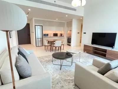 a living room with a couch and a tv and a table at Stunning and Cozy Home with Marina and Sea View in Dubai