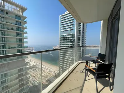 a balcony with two chairs and a view of the ocean at Stunning and Cozy Home with Marina and Sea View in Dubai